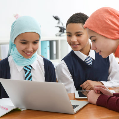 Girls working and learning together behind a laptop