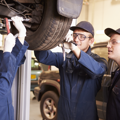 Men learning working on a car Men learning working on a car